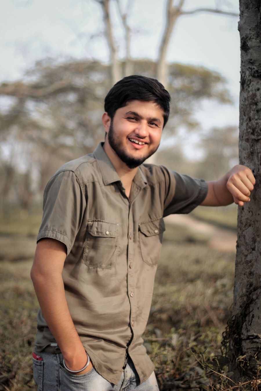 Jonah Ellis leaning against a tree in a park